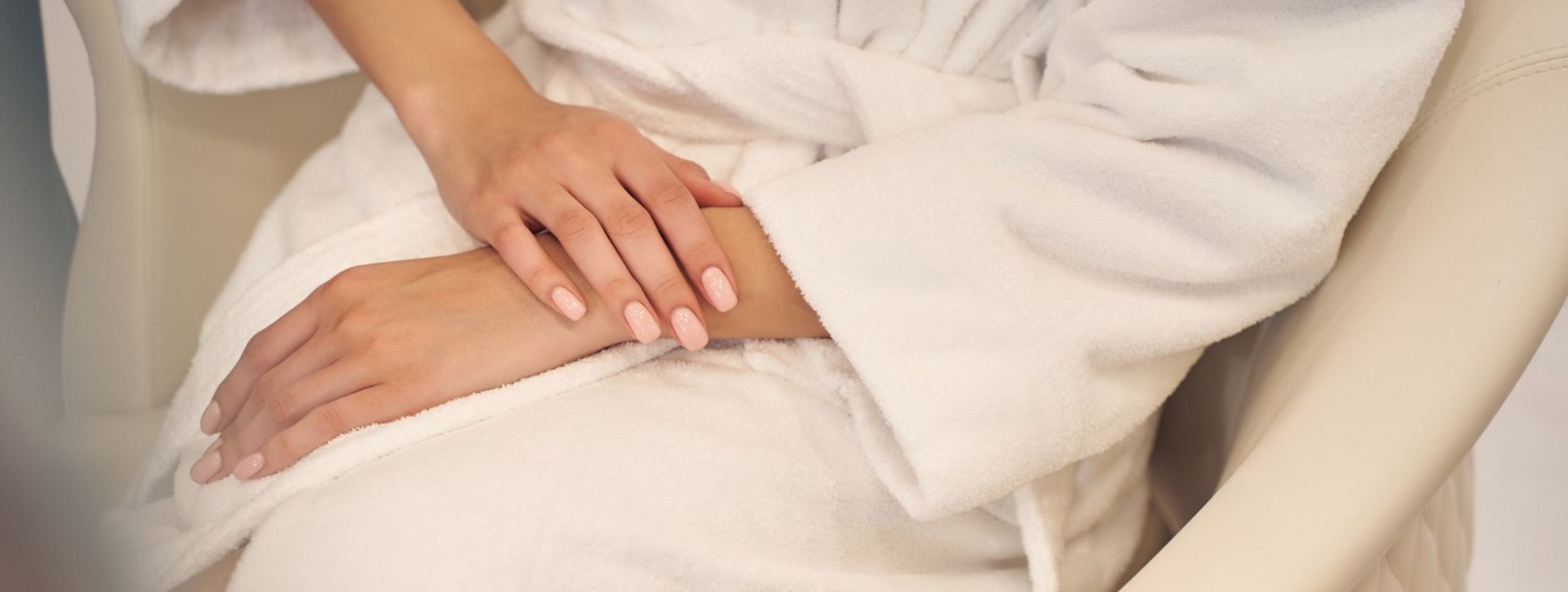 woman's hands folded on a soft bathrobe